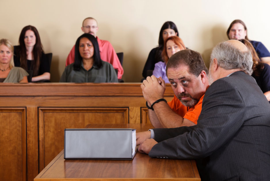 A depiction of a criminal defense lawyer discussing a first-time offender program (i.e., pretrial diversion) with a client in court.