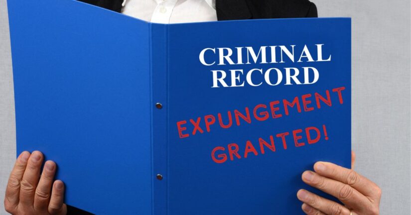 Photo of person holding a criminal record with which shows expungement granted