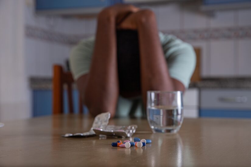 Photo of a Man with Pills on the Table