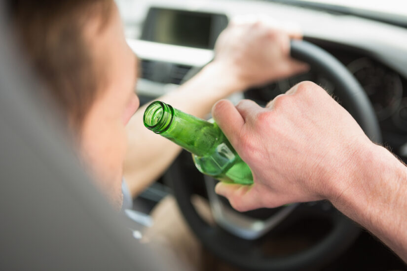 Photo of Man Drinking Beer While Driving