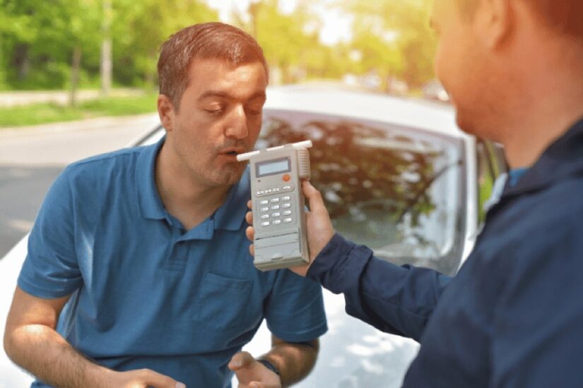Police Officer Performing A Breathalyser Test On A Man