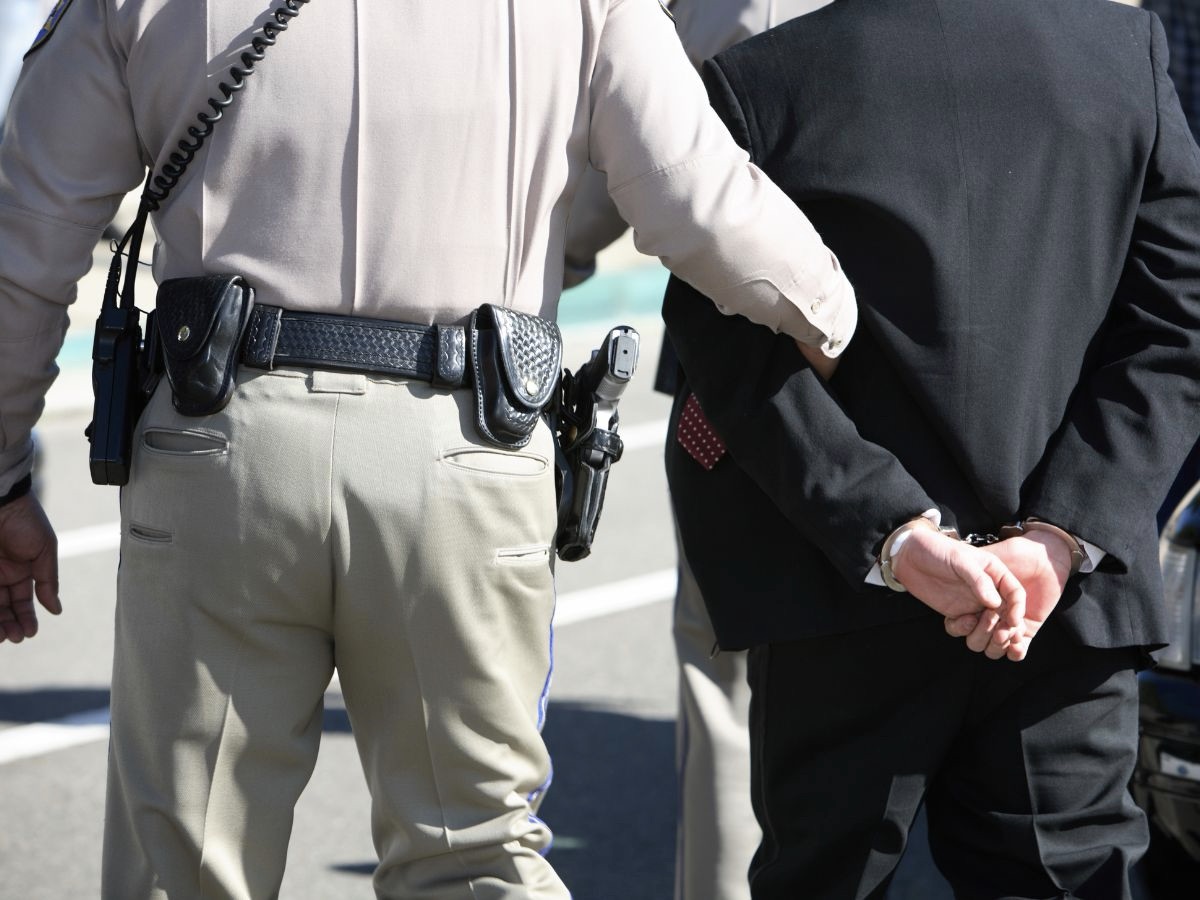 Policeman Escorting Handcuffed Man