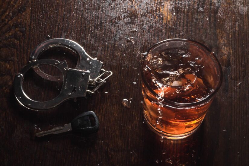 Whiskey rocks with handcuffs and keys symbolizing the arrest of drunk drivers